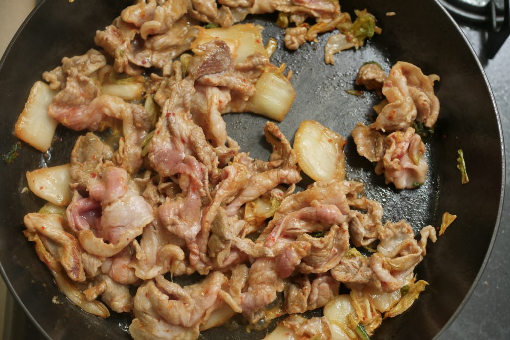 豚こま肉とキムチを炒める